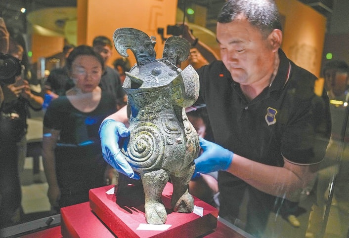 5月15日，在“看·见殷商”展布展现场，工作人员将收藏于国家博物馆的鸮尊摆放入展柜内。