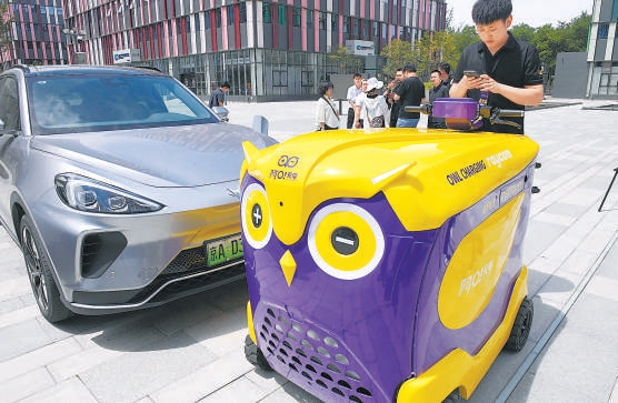 机器人“阿O”正为新能源汽车充电。
