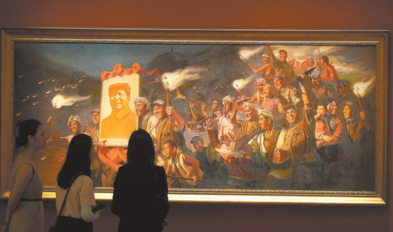参观者欣赏油画《延安的火炬》。这幅画描绘了1945年日本投降后，夜幕下延安军民舞动火炬、庆祝胜利的场景。