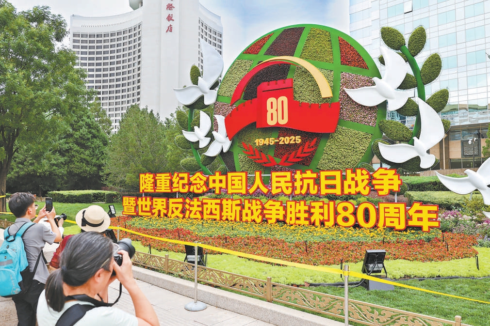 建国门西北角“珍爱和平”主题花坛吸引行人驻足拍照。